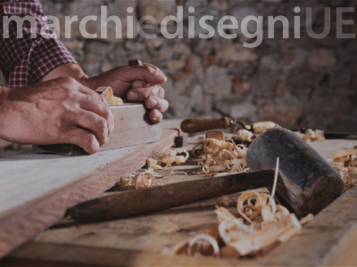mani di artigiano che lavora il legno con logo Marchi e Disegni Ue